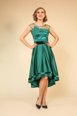 Zarif yeşil elbiseli sarışın genç kadın.