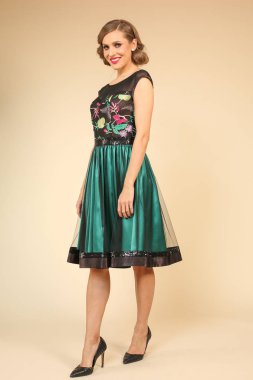 Zarif yeşil elbiseli sarışın genç kadın.