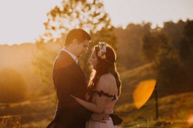 Bahçede poz güzel düğün çifti. Romantik düğün günbatımı.