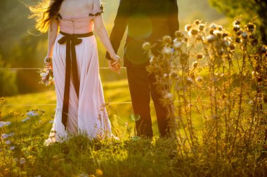 Bahçede poz güzel düğün çifti. Romantik düğün günbatımı.