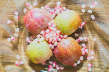 Taze elma dilim ve nar taneleri bir plaka üzerinde.