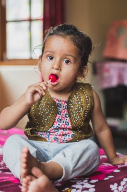 Mutlu Asya bebek çocuk lolipop yemek ile eğleniyor. Lolipop sahip çocuklar