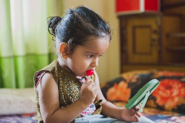 Mutlu Asya bebek çocuk lolipop yemek ile eğleniyor. Lolipop sahip çocuklar