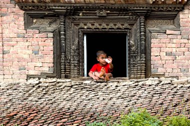 Katmandu, Nepal - Ağustos 17,2018: küçük Nepalce çocuk gösterilen para evinin penceresinden.
