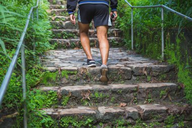 Güçlü kas fitness ve sağlıklı yaşam kavramı merdiven üzerinde çalışan adam atlet. İş adamı elinde cep telefonu taşıyan ile sabah yürüyüşünü yapıyor. Modern egzersiz kavramı.