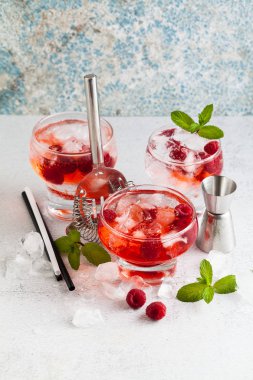 Yaz Ahududu likörü, buz ve masanın üzerine taze nane yaprakları ile alkollü içki. Bar aksesuarları.