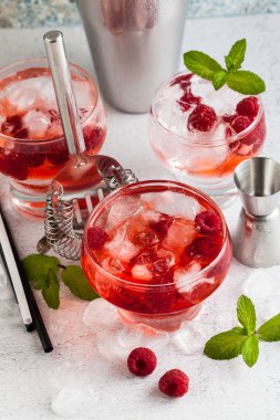 Yaz Ahududu likörü, buz ve masanın üzerine taze nane yaprakları ile alkollü içki. Bar aksesuarları.