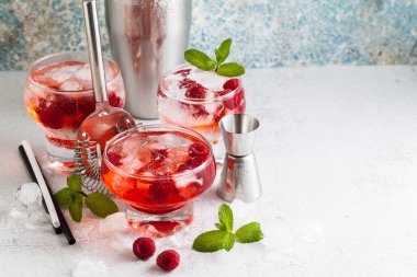 Yaz Ahududu likörü, buz ve masanın üzerine taze nane yaprakları ile alkollü içki. Bar aksesuarları.