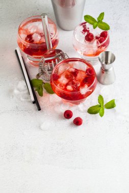 Yaz Ahududu likörü, buz ve masanın üzerine taze nane yaprakları ile alkollü içki. Bar aksesuarları.