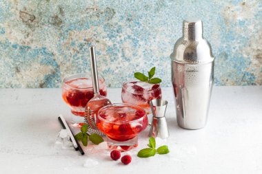 Yaz Ahududu likörü, buz ve masanın üzerine taze nane yaprakları ile alkollü içki. Bar aksesuarları.