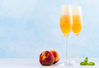iki bardak şampanya Bellini ve taze bir kokteyl ile mavi bir arka plan üzerinde şeftali. içki serinletici yaz