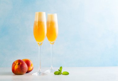 iki bardak şampanya Bellini ve taze bir kokteyl ile mavi bir arka plan üzerinde şeftali. içki serinletici yaz