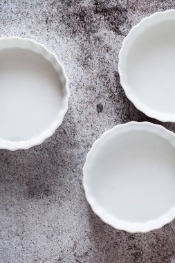 tartlets bir gri taş tabloda pişirme için seramik kalıpları