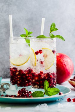 limon ve nar tohumları bir beyaz taş tablo ile alkollü içki ve nane ve bar aksesuarları ile gri arka plan yenileme