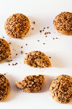 taze pişmiş yulaf ezmeli kurabiye ayçiçeği tohumu, keten tohumu ve susam tohumu ile serpilir. beyaz bir arka plan üzerinde sağlıklı hamur işleri