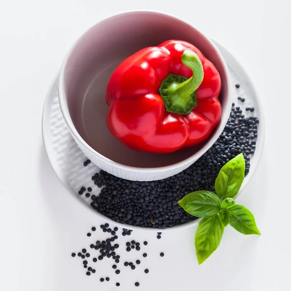 新鲜的红铃椒 罗勒叶和黑扁豆在一组盘子里 — 图库照片