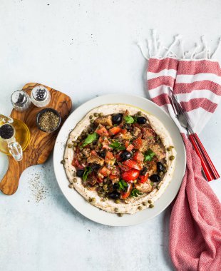 Humus tabakası üzerinde taze Yunan dakos salata. ışık vegan yaz besleyici tarifi