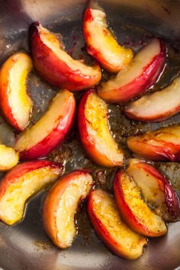 Şeftali masada bir tavada kızarmış parçaları. Pişirme.