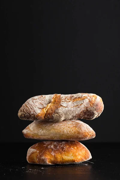 Uma Pilha Pão Italiano Fresco Sobre Fundo Preto — Fotografia de Stock
