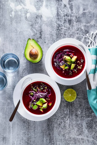 Mavi lahana ile pancar gazpacho çorbası, avokado ve yeşil soğan ile limon suyu masada. sağlıklı yaz vegan gıda 