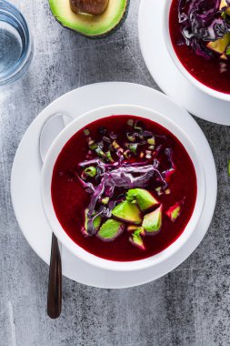 Mavi lahana ile pancar gazpacho çorbası, avokado ve yeşil soğan ile limon suyu masada. sağlıklı yaz vegan gıda 