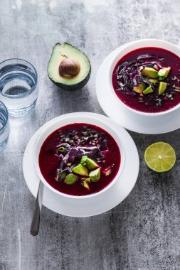 Mavi lahana ile pancar gazpacho çorbası, avokado ve yeşil soğan ile limon suyu masada. sağlıklı yaz vegan gıda 