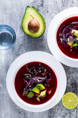 Mavi lahana ile pancar gazpacho çorbası, avokado ve yeşil soğan ile limon suyu masada. sağlıklı yaz vegan gıda 