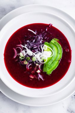 Mavi lahana ile pancar gazpacho çorbası, avokado ve yeşil soğan ile limon suyu masada. sağlıklı yaz vegan gıda 