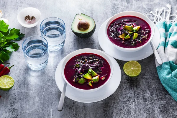 Mavi lahana ile pancar gazpacho çorbası, avokado ve yeşil soğan ile limon suyu masada. sağlıklı yaz vegan gıda 