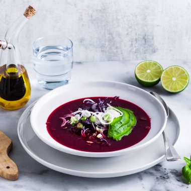 Mavi lahana ile pancar gazpacho çorbası, avokado ve yeşil soğan ile limon suyu masada. sağlıklı yaz vegan gıda 