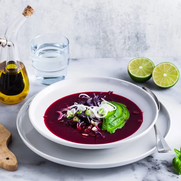 Mavi lahana ile pancar gazpacho çorbası, avokado ve yeşil soğan ile limon suyu masada. sağlıklı yaz vegan gıda 