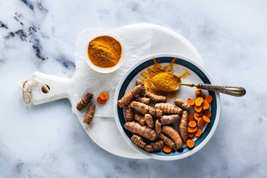 zerdeçal ve beyaz mermer tahta ve masa--dan o toz kökleri. sağlıklı doğal takviyeleri, yemek pişirmek için baharat