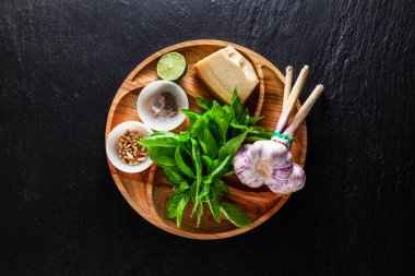 İtalyan Klasik yeşil pesto fesleğen sos yemek için taze malzemeler. çam fıstığı, sarımsak ve parmesan peyniri. bir siyah arduvaz masaya. kopya alanı