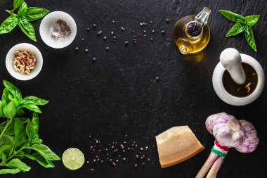 İtalyan Klasik yeşil pesto fesleğen sos yemek için taze malzemeler. çam fıstığı, sarımsak ve parmesan peyniri. bir siyah arduvaz masaya. kopya alanı