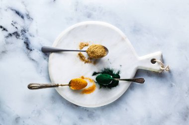 zencefil ve zerdeçal tozu ve Yönetim Kurulu ve beyaz mermer masada yemek kaşığı hawaiian spirulina. sağlıklı takviyeleri, superfoods pişirme