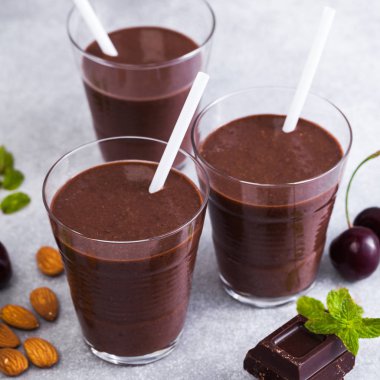 Kara Orman smoothies gri yüzeyi tablo. çikolatalı milkshake ile fındık ve kiraz