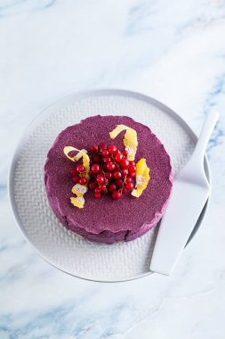 Klasik blueberry limon cheesecake mermer bir tabloda bir pasta stand.