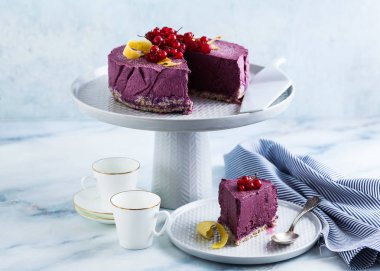 Klasik blueberry limon cheesecake mermer bir tabloda bir pasta stand.