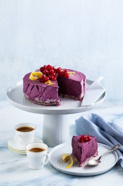 Kaju fıstığı ve yaban mersini çiğ vegan kek. sağlıklı tatlılar. süt, un ve ücretsiz gluten. ve iki mermer bir masada kahve espresso fincan