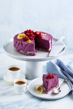 Kaju fıstığı ve yaban mersini çiğ vegan kek. sağlıklı tatlılar. süt, un ve ücretsiz gluten. ve iki mermer bir masada kahve espresso fincan