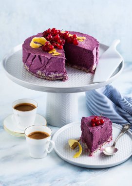 Klasik blueberry limon cheesecake kek stand mermer bir tablo. ve iki espresso fincan