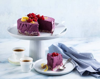 Kaju fıstığı ve yaban mersini çiğ vegan kek. sağlıklı tatlılar. süt, un ve ücretsiz gluten. ve iki mermer bir masada kahve espresso fincan