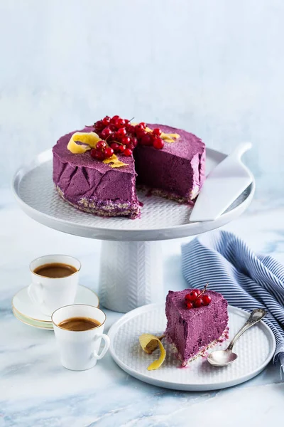 Kaju fıstığı ve yaban mersini çiğ vegan kek. sağlıklı tatlılar. süt, un ve ücretsiz gluten. ve iki mermer bir masada kahve espresso fincan