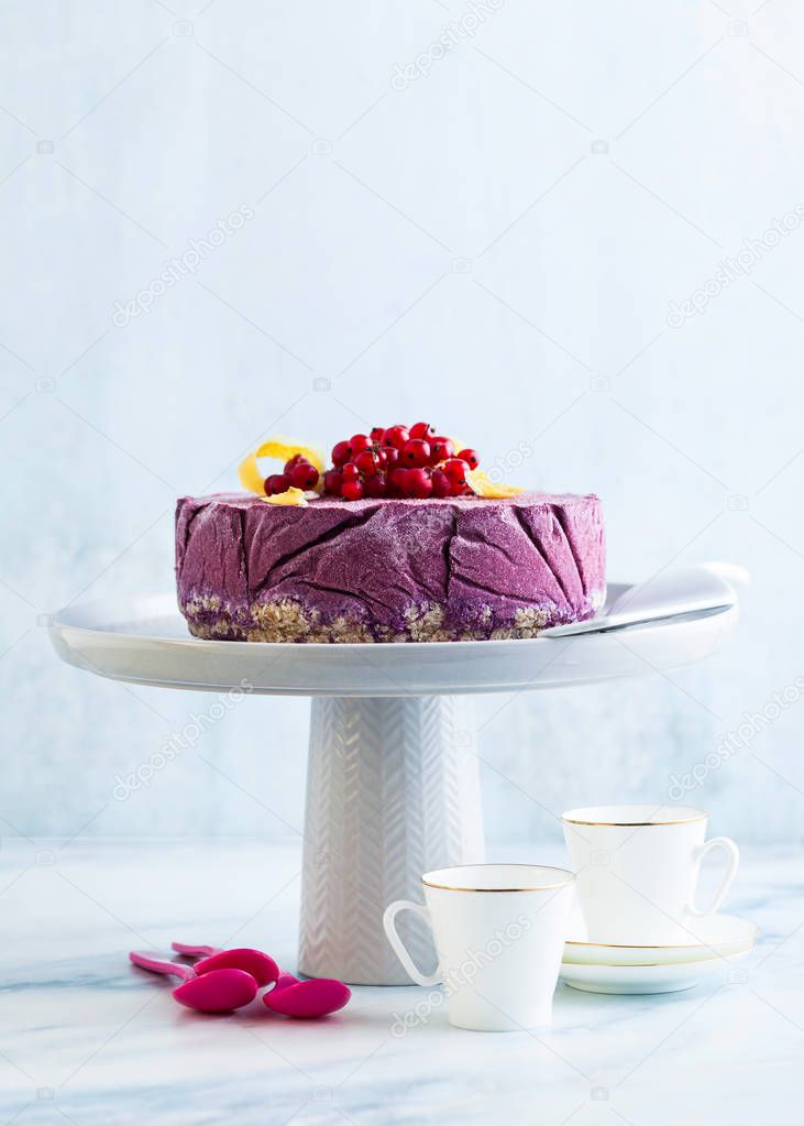 frozen blueberry lemon cake from ice cream and fresh berries on a cake stand on a marble table. summer festive dessert