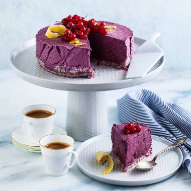 Kaju fıstığı ve yaban mersini çiğ vegan kek. sağlıklı tatlılar. süt, un ve ücretsiz gluten. ve iki mermer bir masada kahve espresso fincan