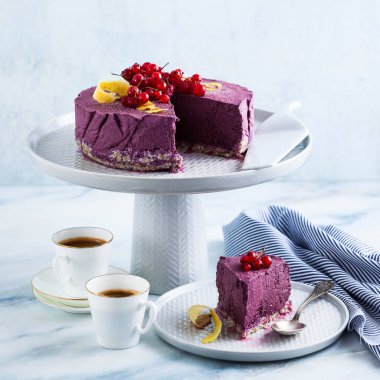 Kaju fıstığı ve yaban mersini çiğ vegan kek. sağlıklı tatlılar. süt, un ve ücretsiz gluten. ve iki mermer bir masada kahve espresso fincan