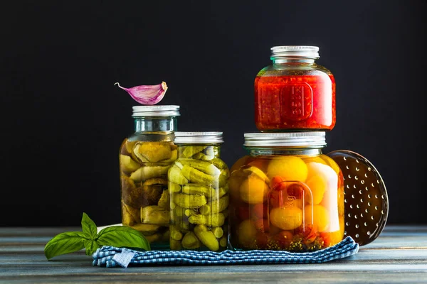 Ahşap arka plan üzerinde sebze korunmuş. Kış sonbahar kutular