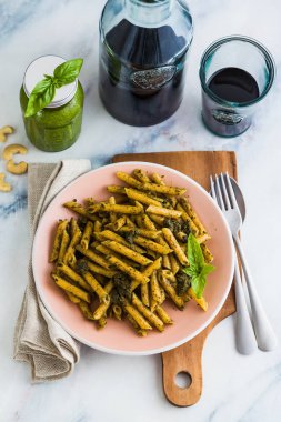Kepekli makarna yemek masada kırmızı şarap fesleğen pesto ile. ışık Akdeniz çanağı. Vegan sağlıklı gıda
