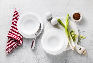 Tablo boş beyaz tabak çorba ve yeşil soğan için servis. sağlıklı mutfak