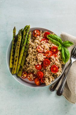 sorgum (büyük darı), glutensiz dan salata ızgara kuşkonmaz ve domates tahin susam makarna sosu ve limon suyu ile masaya bir tabak. Çölyak hastalığı olan hastalar için sağlıklı vejetaryen mutfağı 